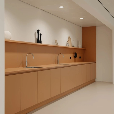 Moderne pantry met bruin-oranje kasten en dubbele wasbak in kantoorpand aan Nachtwachtlaan 20, Amsterdam West.