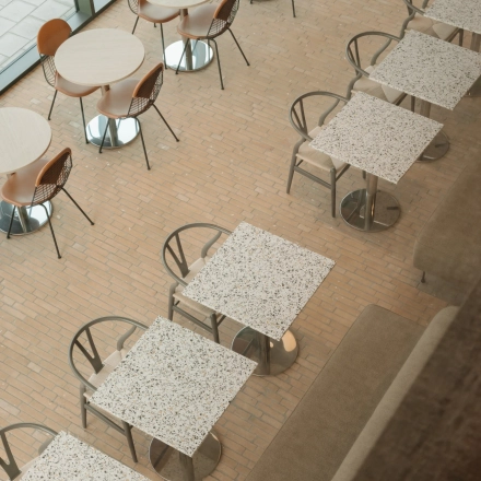 Bovenaanzicht van een gemeubileerde kantoorruimte aan de Nachtwachtlaan 20, Amsterdam West, met tafels en stoelen geschikt voor zakelijke bijeenkomsten of pauzes.