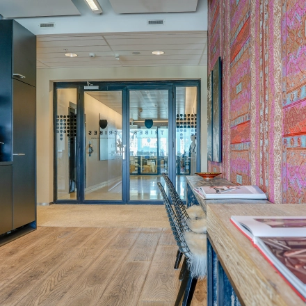Kantoorpand in Amsterdam Zuid-Oost met kleurrijke wandbekleding en moderne koffiehoek. Perfect voor kantoorruimte huren. De stijl is eigentijds en uitnodigend, ideaal voor een professionele werkruimte.