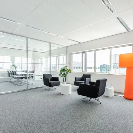 Lichte, moderne kantoorruimte huren aan de Herikerbergweg 240-286, Amsterdam Zuid-Oost, met glazen wanden, een vergadertafel en comfortabele stoelen.