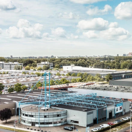 Luchtfoto van een kantoorpand aan de Herikerbergweg 240-286 in Amsterdam Zuid-Oost, omgeven door andere bedrijfsgebouwen en een groene omgeving.