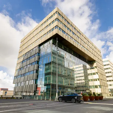 Het kantoorpand aan de Herikerbergweg 288 in Amsterdam Zuid-Oost met een moderne glazen gevel en voldoende parkeergelegenheid, ideaal om kantoorruimte te huren.
