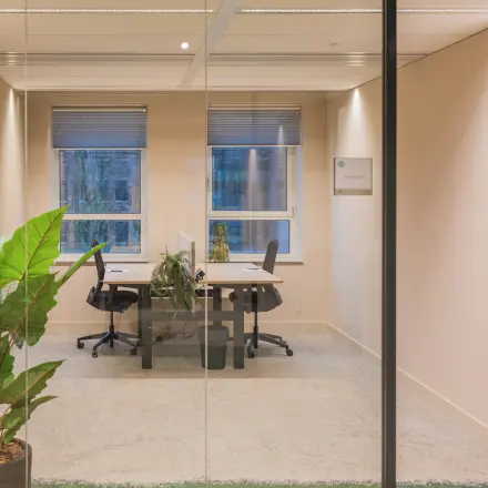 Heldere kantoorruimte huren aan Hullenbergweg 109-135, Amsterdam Zuid-Oost. Compact, met glazen wanden, planten en bureaus met stoelen.