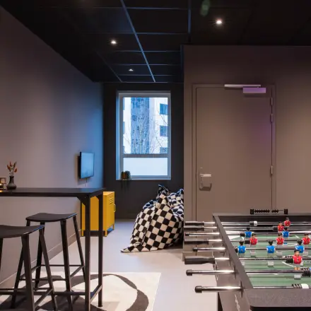 Speelse kantoorruimte te huur op Hullenbergweg 109-135 in Amsterdam Zuid-Oost, met een tafelvoetbaltafel en zitgedeelte. Ideaal voor ontspannen pauzes tussen het werken door.