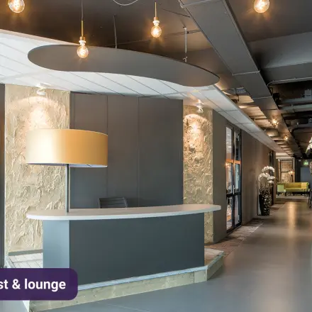 Moderne kantoorlobby met ontvangstbalie en stijlvolle verlichting op Johan Cruijff Boulevard 89, perfect voor kantoorruimte huren in Amsterdam Zuid-Oost.