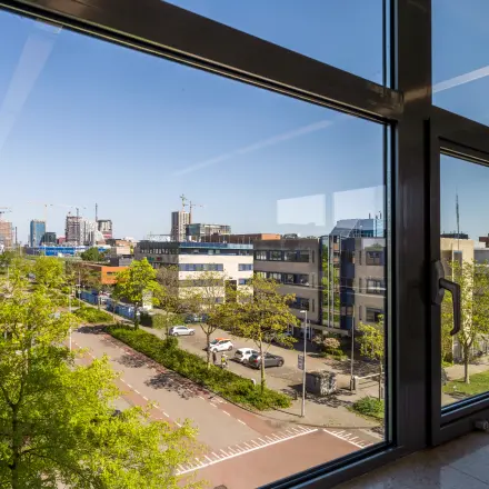 Uitzicht vanuit een kantoorruimte op Paasheuvelweg 20, Amsterdam Zuid-Oost met stedelijke omgeving en hoge gebouwen.