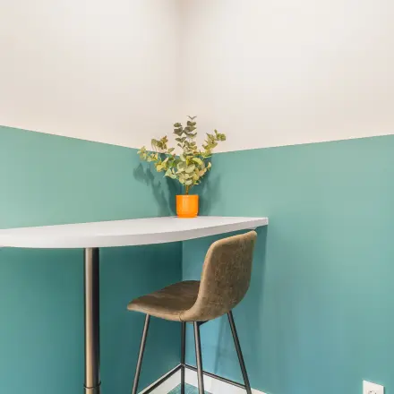 Gezellige hoek van een kantoorpand aan de Paasheuvelweg 20 in Amsterdam Zuid-Oost met een hoge tafel en stoel, ideaal voor informeel werken of pauzes. Perfect voor kantoorruimte huren.