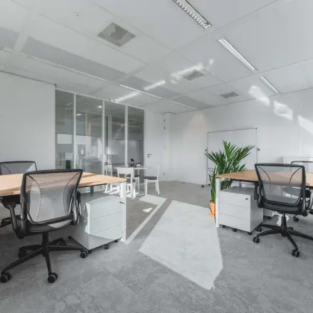 Moderne kantoorruimte te huur op Barbara Strozzilaan 101, Amsterdam Zuidas, met strakke bureaus, bureaustoelen en veel natuurlijk licht door grote ramen.