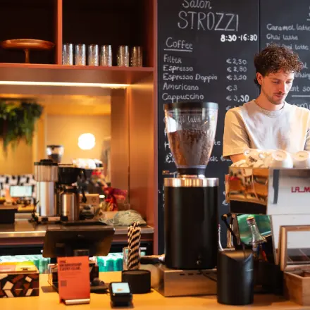 Een barista bereidt koffie in een modern ingerichte koffiehoek in een kantoorpand aan de Barbara Strozzilaan 101 in Amsterdam Zuidas.