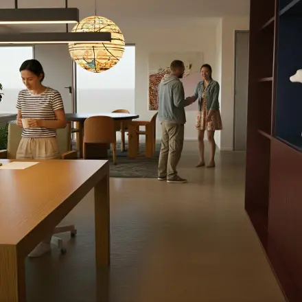 Moderne kantoorruimte op Barbara Strozzilaan 101, Amsterdam Zuidas, met mensen die werken en overleggen rondom houten tafels, sfeerverlichting en grote planten.