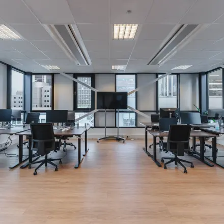 Moderne kantoorruimte met grote ramen aan De Boelelaan 30, Amsterdam Zuidas, voorzien van bureaus, stoelen en computerschermen, geschikt voor zakelijk gebruik of kantoorruimte huren.