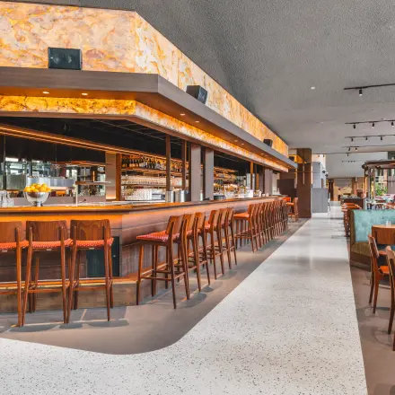 Moderne en stijlvolle bar met houten krukken en gezellige zitplekken in een kantoorpand in Amsterdam Zuidas.