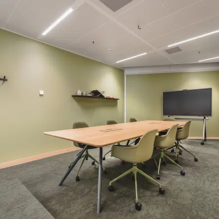Kantoorruimte huren op Hildegard Von Bingenstraat 44, Amsterdam Zuidas, met moderne vergadertafel en stoelopstelling, ideaal voor zakelijke bijeenkomsten.