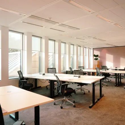 Heldere kantoorruimte aan Jachthavenweg 109 in Amsterdam Zuidas, met ruime bureaus en ergonomische stoelen om te huren als kantoor. Grote ramen zorgen voor veel natuurlijk licht in dit kantoorpand.