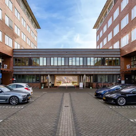 Kantoorpand Het Rietveld 55-59 in Apeldoorn met geparkeerde auto's op het terrein; ideaal voor kantoorruimte huren.