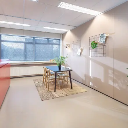 Kantoorpand op Oude Apeldoornseweg 41-45 in Apeldoorn met een moderne vergaderruimte inclusief tafel, stoelen en planten. Ideaal voor wie kantoorruimte wil huren.