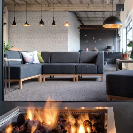 Moderne kantoorruimte huren op Oude Apeldoornseweg 41-45, Apeldoorn. Gemeubileerde lounge met comfortabele banken en sfeervolle verlichting. Personen voeren zakelijke gesprekken uit.