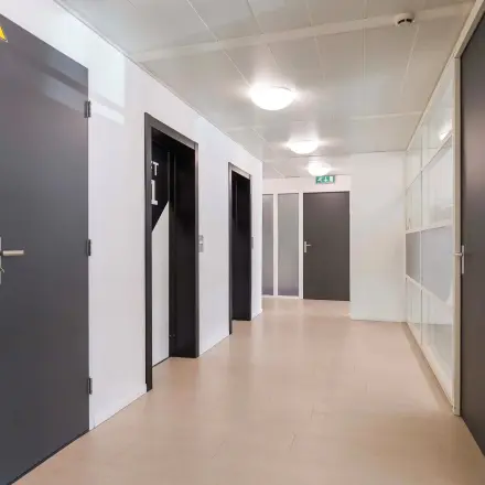 Gang in kantoorpand op Prins Willem-Alexanderlaan 301 in Apeldoorn met meerdere deuren en glazen wanden.