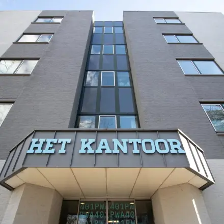 De voorzijde van een kantoorpand aan de Prins Willem-Alexanderlaan 401 in Apeldoorn, met een modern design en grote ramen.