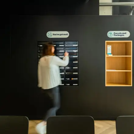 Een persoon haalt post op in een modern kantoorpand aan de Prins Willem Alexanderlaan 701 in Apeldoorn. Geschikt voor kantoorruimte huren met voorzieningen voor post en pakketten.