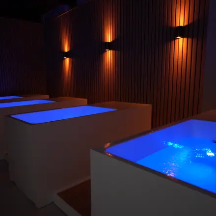 Moderne ontspanningsruimte in kantoorpand op Schumanpark 9, Apeldoorn, met sfeerverlichting en glanzend water in ligbaden.