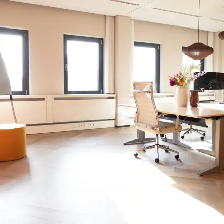 Kantoorruimte op Schumanpark 9 in Apeldoorn met moderne werkplekken, bureaustoelen en decoratieve verlichting, ideaal voor wie kantoorruimte wil huren.