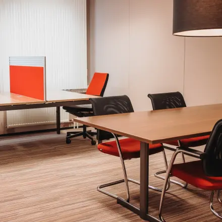 Gemeubileerde kantoorruimte op Vlamoven 34, Arnhem IJsseloord met vergadertafel, stoelen en werkplekken. Perfect voor het huren van kantoren in een moderne omgeving.