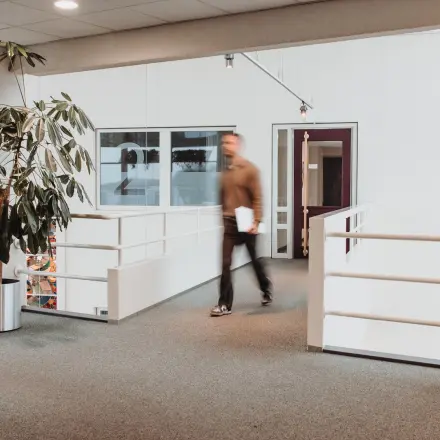 Kantoorruimte op Vlamoven 34 in Arnhem IJsseloord met moderne inrichting en rustige kleuren. Personen voeren zakelijke activiteiten uit in de kantoorpand. Ideaal voor kantoorruimte huren.