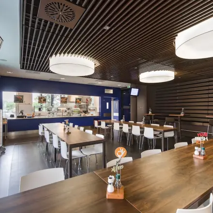 Binnenruimte in het kantoorpand op Kronenburgsingel 525, Arnhem Zuid met moderne tafels en een bedrijfskeuken. Ideaal voor kantoren die ruimte willen huren in een functionele omgeving.