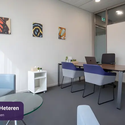 Moderne kantoorruimte te huur in Arnhem Zuid met strakke inrichting, inclusief vier werkplekken en kunstwerken aan de muur.