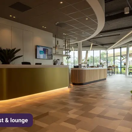 Moderne kantoorruimte huren op Stationsplein 10 in Assen, met een uitnodigende lounge en receptie. Strakke meubels en veel lichtinval maken het een ideale plek voor zakelijke ontmoetingen.