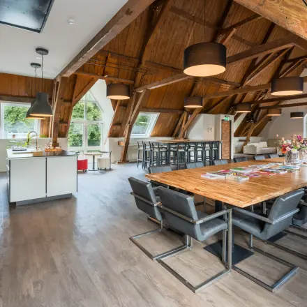 Ruime kantoorpand op Blokstallen 2B in Bergen op Zoom met houten details, een lange tafel en moderne inrichting. Ideaal voor kantoorruimte huren.
