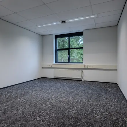 Ongemeubileerd kantoor op Rijtuigweg 10 in Bergen op Zoom met tapijt, witte muren en een raam. Een ruimte ideaal voor kantoorruimte huren of andere zakelijke activiteiten.