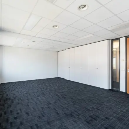 Kantoorruimte te huur aan Tolnasingel 1 - 3 in Bodegraven met zwart tapijt en witte muren. Geschikt voor verschillende indelingen en toepassingen.