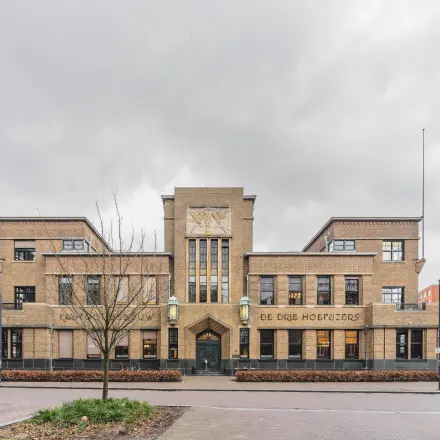 Vooraanzicht van een indrukwekkend kantoorpand aan de Ceresstraat 13 in Breda Centrum-Station. Het gebouw heeft een klassieke uitstraling met bakstenen en grote ramen.