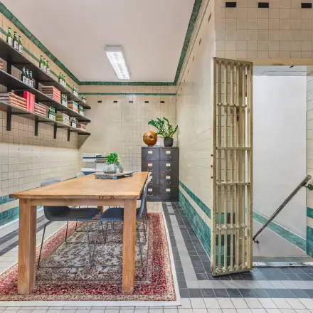 Unieke kantoorruimte huren in een pand op Ceresstraat 13, Breda Centrum-Station, met karakteristieke tegelwanden en een houten bureau, ideaal voor creatieve zakelijke activiteiten.