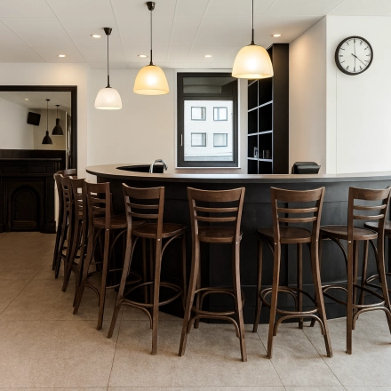 Moderne kantoorruimte huren in Breda Oost aan de Druivenstraat 25-31, met een stijlvolle bar en comfortabele houten stoelen, ideaal voor informele vergaderingen.