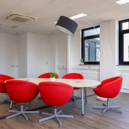 Eigentijdse kantoorruimte huren met rode stoelen en moderne verlichting in het kantoorpand op Druivenstraat 25-31 in Breda Oost.