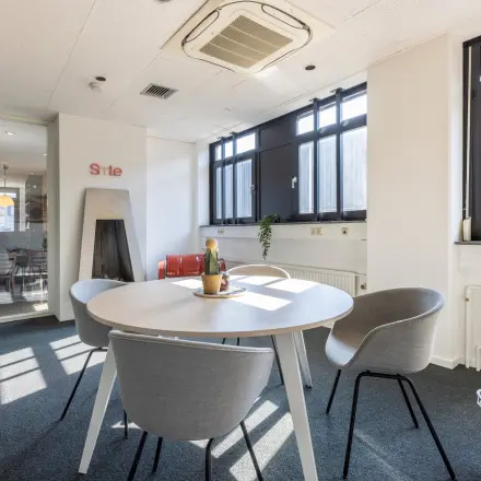Kantoorruimte huren aan de Druivenstraat 25-31 in Breda Oost, met modern interieur en grote ramen die natuurlijk licht binnenlaten. Geschikt voor overleg of als werkkamer.