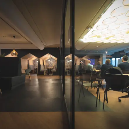 Binnen in het kantoorpand Rietbaan 2-12, Capelle aan den IJssel zijn mensen aan het vergaderen in een stijlvol ingerichte ruimte. Ideaal voor kantoorruimte huren met moderne voorzieningen.