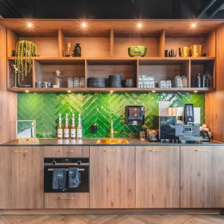 Stijlvolle pantry met houten kasten en groene tegelwand, ideale kantoorruimte huren in kantoorpand Rijnzathe 12, De Meern.