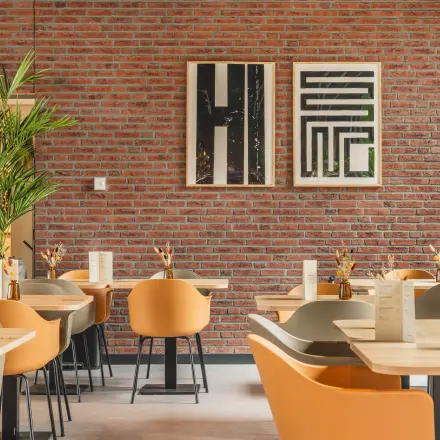 Moderne kantoorruimte huren in De Meern met stijlvolle zitplaatsen en sfeervolle decoratie tegen een bakstenen muur.