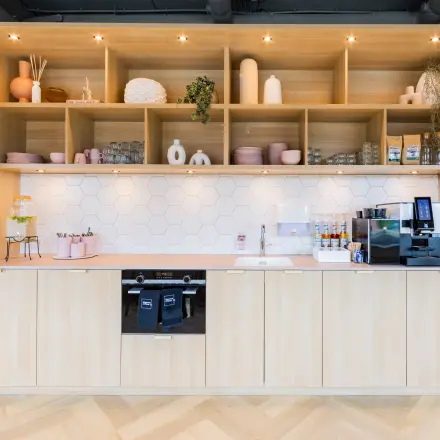 Stijlvolle pantry met houten kasten en moderne apparatuur in een kantoorpand op Rijnzathe 12, De Meern. Ideaal voor een pauze tijdens het kantoorwerk. Overweeg deze ruimte te huren.