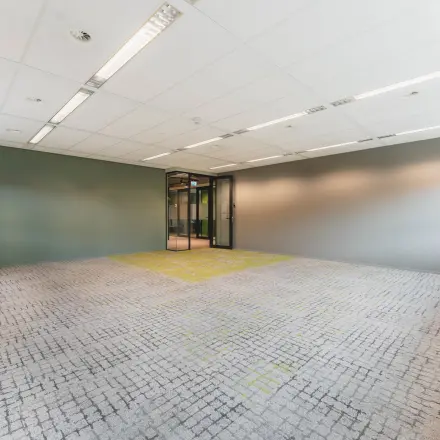Kantoorruimte huren aan Rijnzathe 12 in De Meern, met neutrale muren en een tapijtpatroon. Grote ramen zorgen voor veel natuurlijk licht in het kantoorpand.