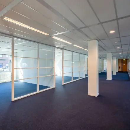 Ruime kantoorruimte met glaswanden en zachte verlichting op Delftechpark 17-19, Delft, ideaal voor wie een kantoorpand wil huren.