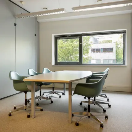 Compacte kantoorruimte huren op Delftechpark 9 in Delft, voorzien van een vergadertafel en stoelen met uitzicht op groen. Ideaal voor kleine bijeenkomsten in een rustige omgeving.