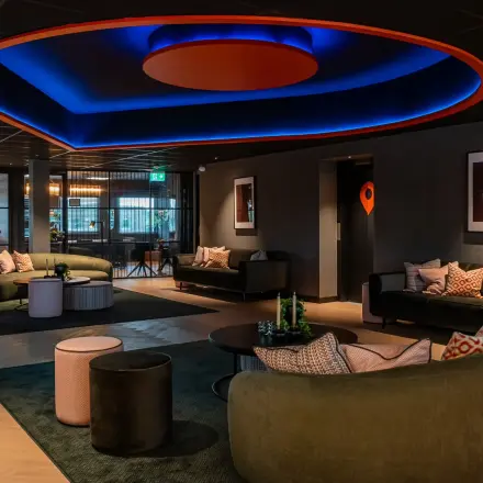 Moderne kantoorruimte in kantoorpand op Reitschweg 1, Den Bosch, met stijlvolle zitgedeelten en sfeervolle belichting. Ideaal voor huur en zakelijke bijeenkomsten.