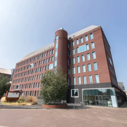 Kantoorgebouw op Willemsplein 2 in Den Bosch met markante ronde toren en bakstenen gevel. Ideale locatie voor kantoorruimte huren met ruime parkeergelegenheid.