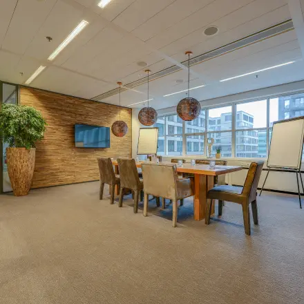 Ruime, gemeubileerde vergaderruimte met houten tafel en stoelen, grote ramen en moderne verlichting, ideaal voor kantoorruimte huren op Kalvermarkt 53 in Den Haag Centrum.