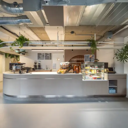 Moderne receptieruimte met een koffiebar op Koninginnegracht 10 in Den Haag Centrum, geschikt om te huren als kantoorruimte.